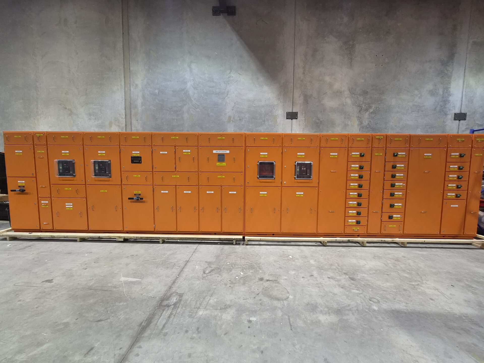 A completed run of custom orange switchboards in the In Control workshop